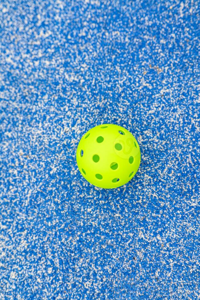An Abstract Background of a Pickleball on a Blue Floor. Concept The patterns and textures of sport. photo