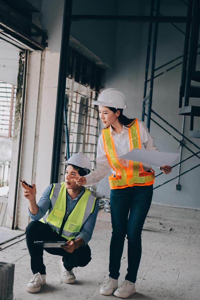 Two people in hard hats and safety vests standing in an unfinished building photo