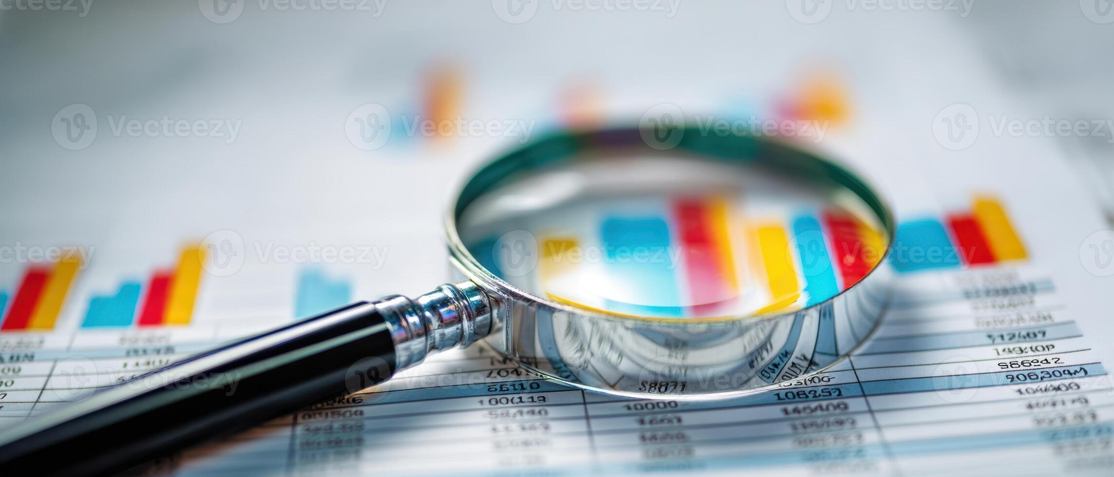 The magnifying glass highlighting important data on financial performance graphs. photo