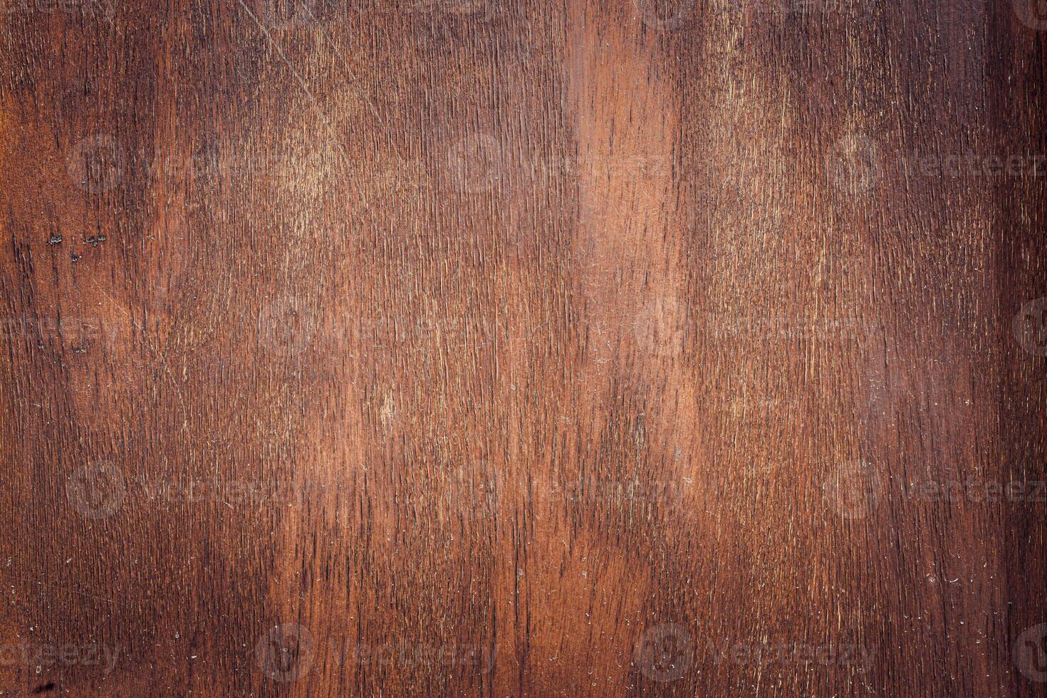 Close-up of textured wooden surface with rich brown tones and natural grain patterns. Ideal for backgrounds or rustic themes. photo