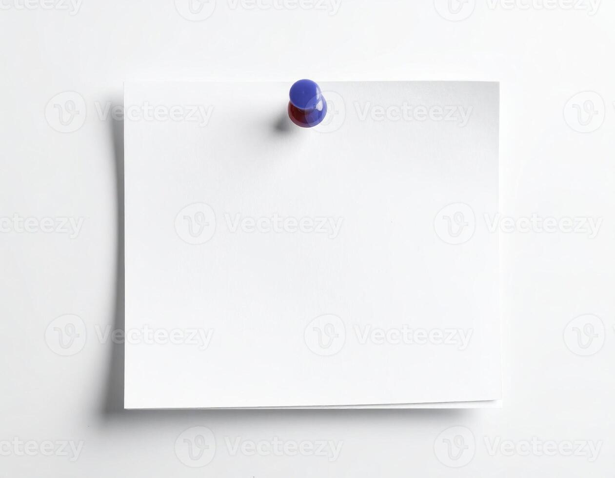 A white notepad with a thumbtack placed on it against a plain white backdrop photo