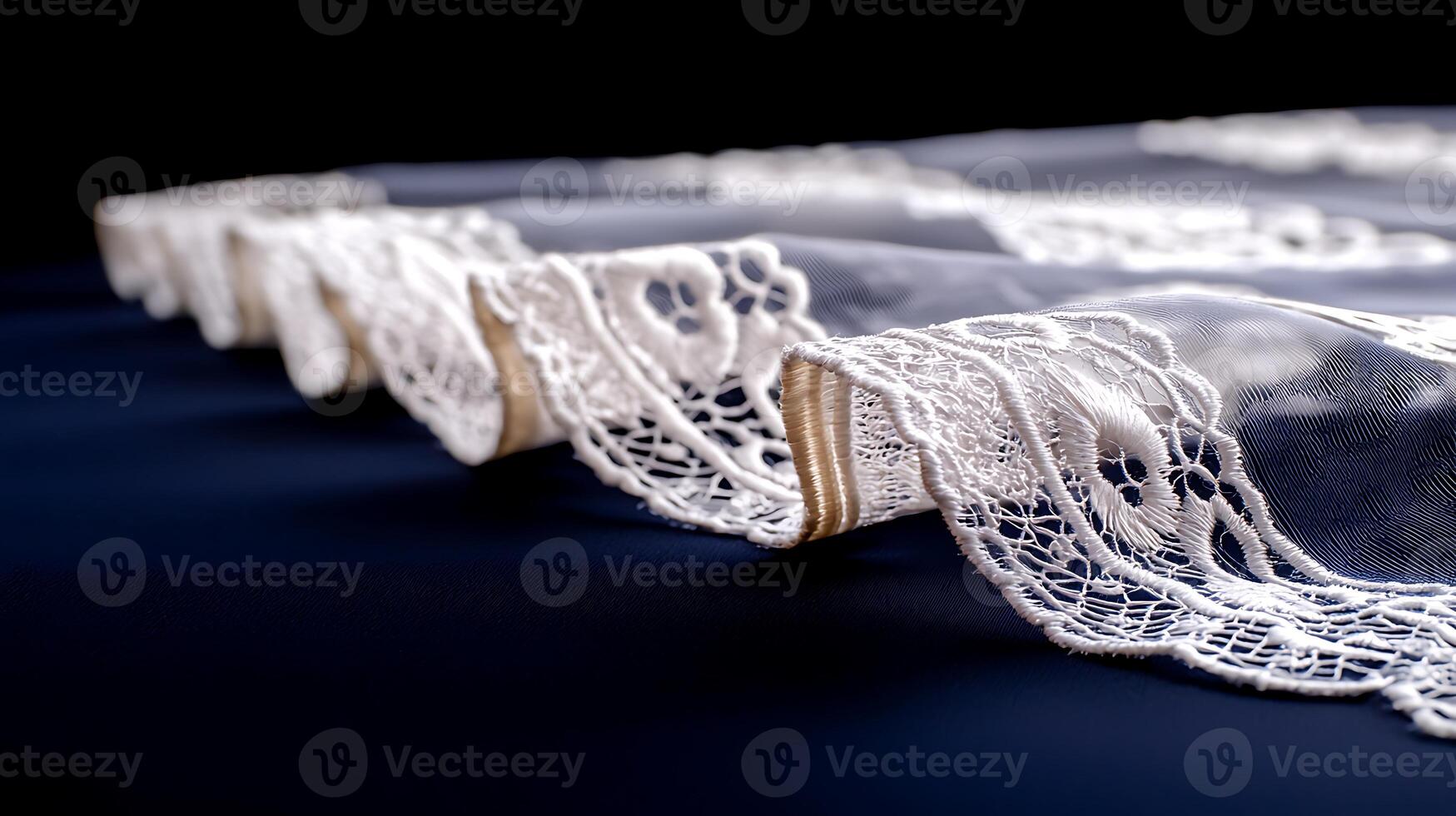 Delicate lace fabric draped elegantly on a dark surface, showcasing intricate patterns and textures photo