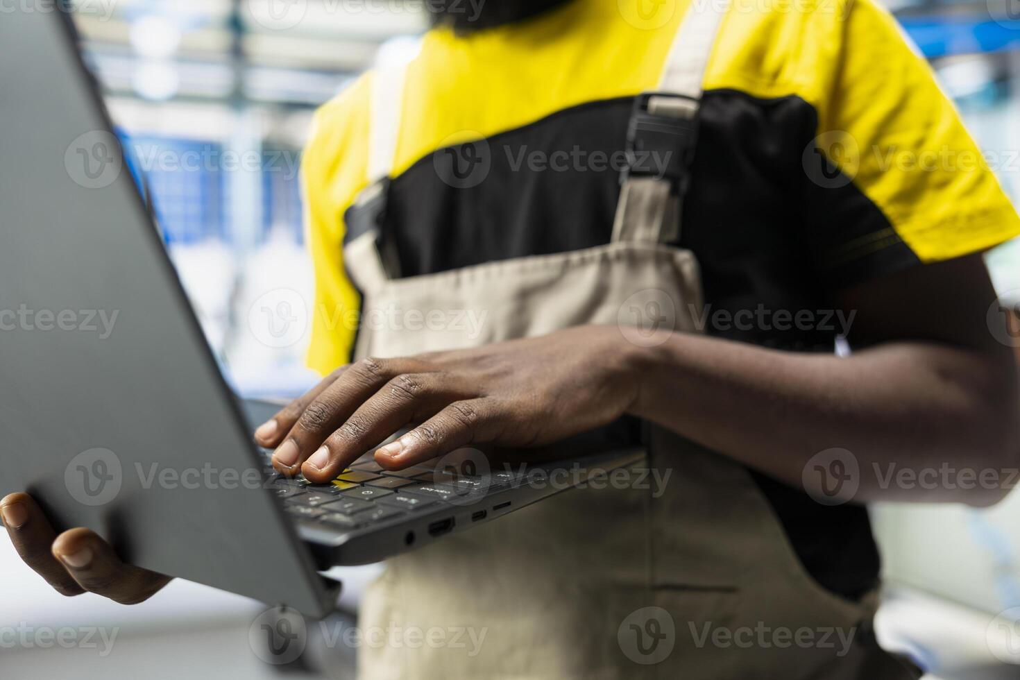 Black technician works on solar energy software settings in high tech factory, optimizing the production process. Optimal system configuration with digital tools and industrial robotics. photo