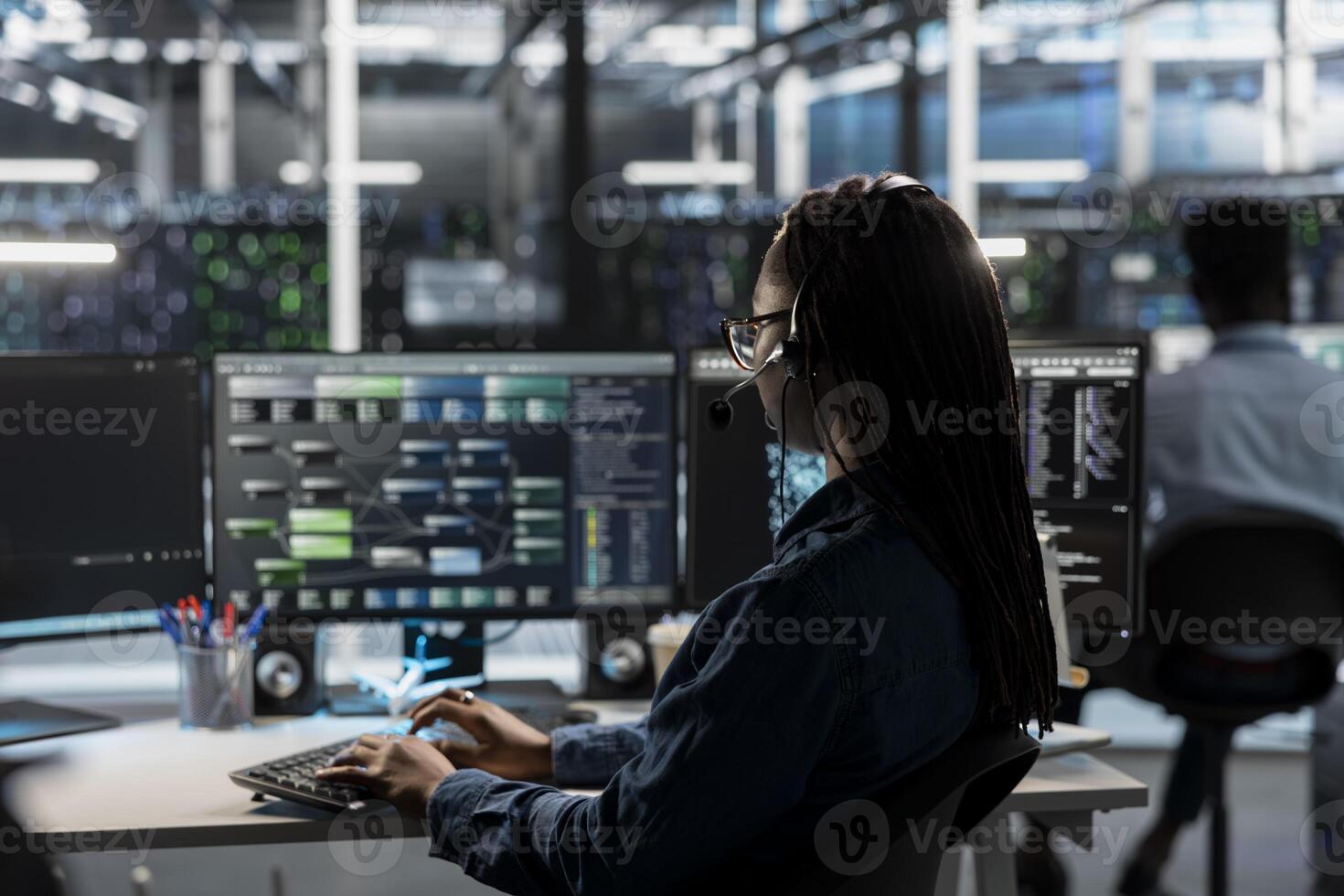 IT expert in data center wearing audio headset providing technical support to customers, troubleshooting errors. Server farm employee doing operational technical interventions requested by clients photo
