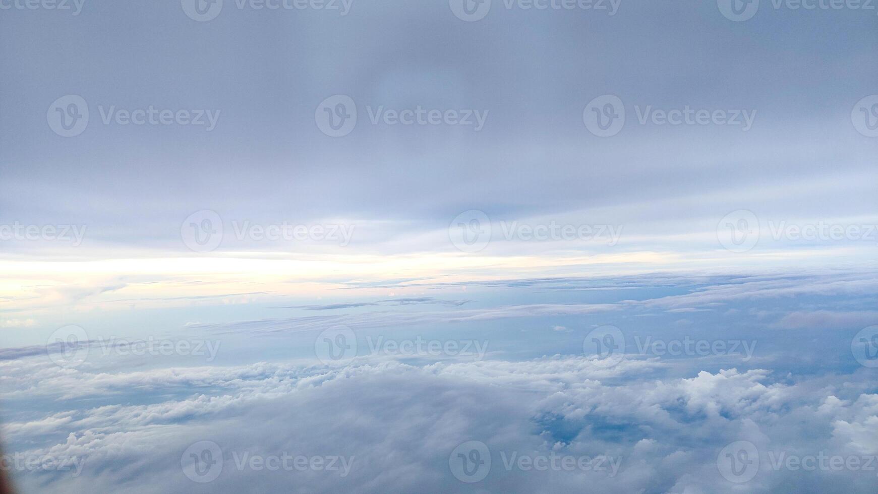 A serene sky view featuring soft clouds taken from a plane in flight photo