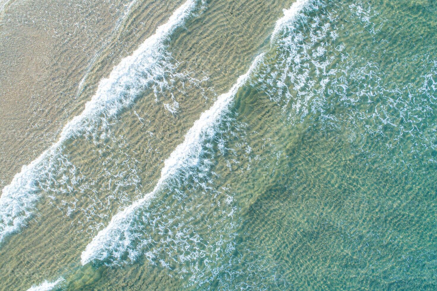 Top down aerial view of multiple waves on a shallow beach. A Rhythmic Pattern photo