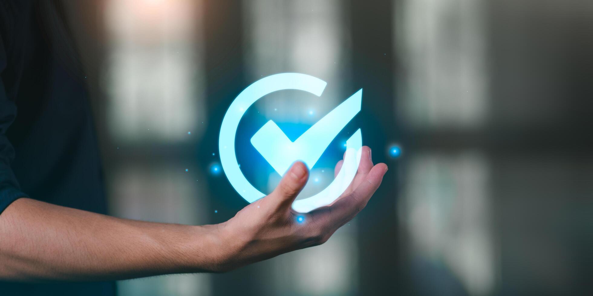 Verification and approval concept in digital business. Hand with glowing check mark icon represents trust, validation, completed tasks, and certified process in quality control and online systems. photo