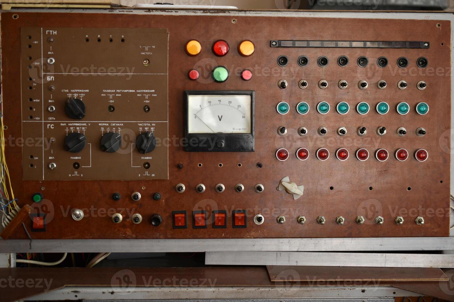 An old control board with a voltmeter, switches and lamps. Electronic control panel with buttons and toggle switches. The old management system. photo