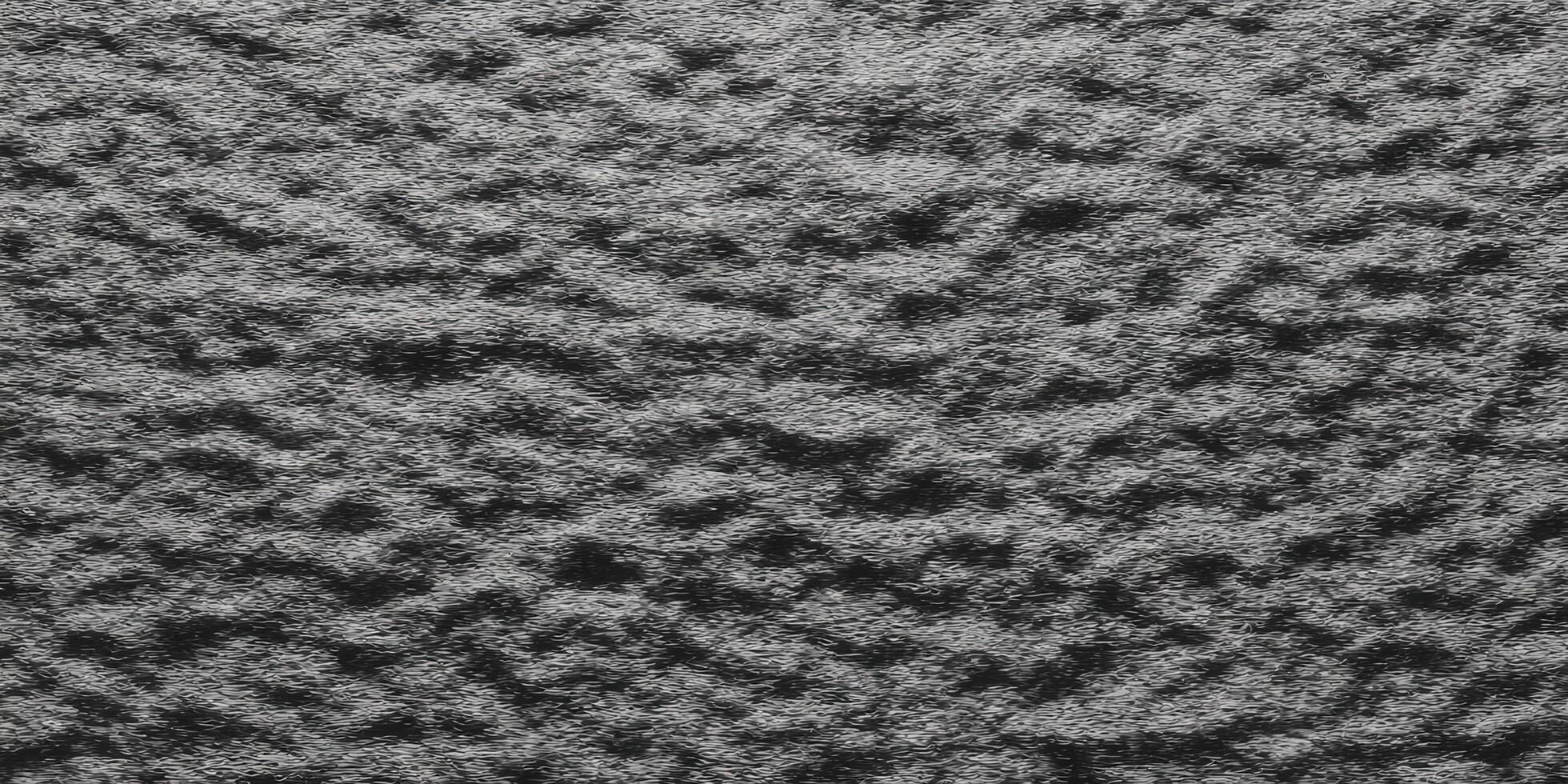 Detailed view of a textured, dark gray surface with a rough and uneven pattern. photo