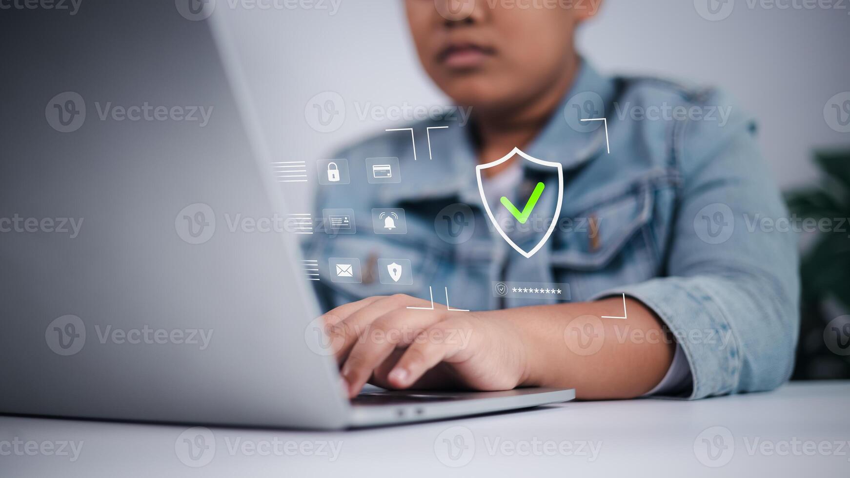 Cyber security concept showing Asian boy using laptop with digital interface, symbolizing online safety, data privacy, and child internet protection. photo