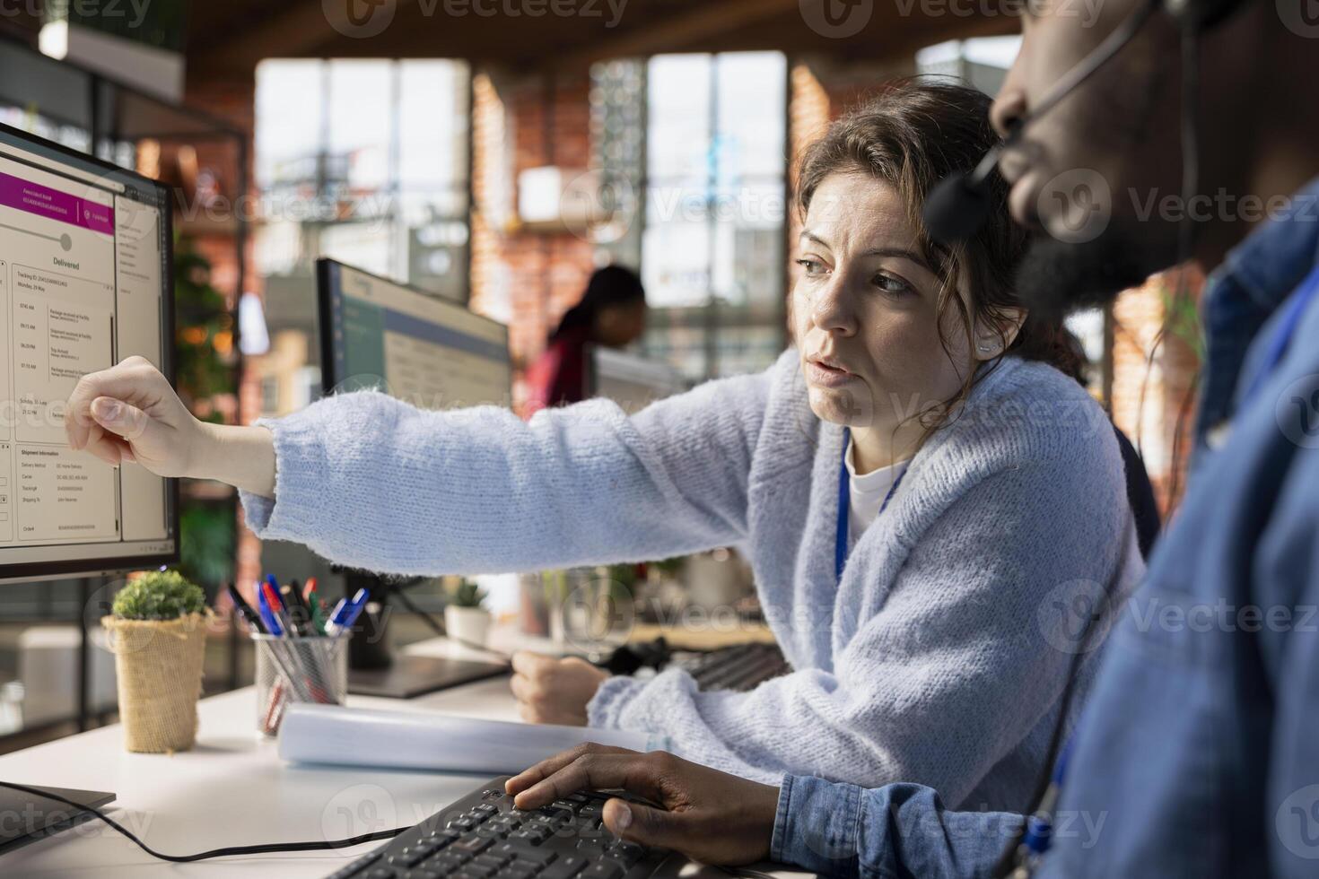Customer service manager teaching new employee how to track support tickets in dedicated company software on PC. Call center supervisor shows intern how to create, update and close support tickets photo