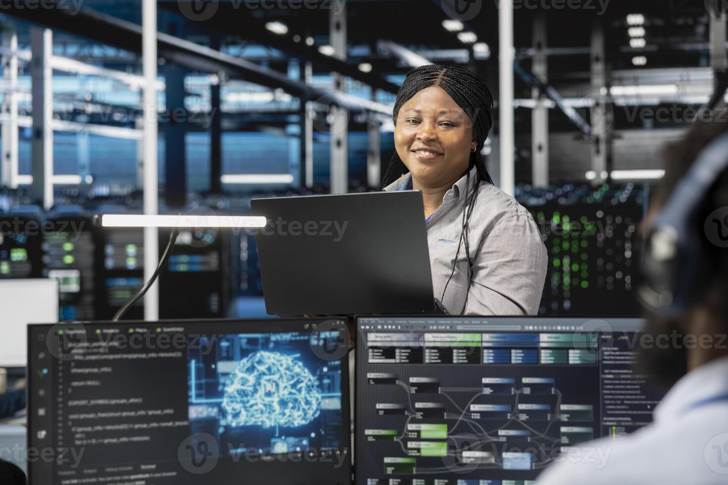 Portrait of smiling software developer working in data center with artificial intelligence tech to process massive datasets. Happy IT professional in server hub storing data used for deep learning photo