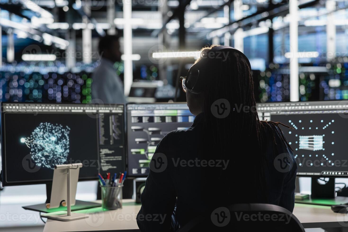 Data center admin uses AI visualization tool on PC to optimize resource allocation. Server farm employee uses artificial intelligence analysis software on computer to do maintenance photo