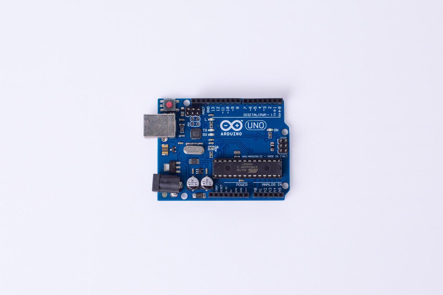 Malang, March 24, 2025. Top view of Arduino Uno microcontroller board on white background. DIY electronics, robotics, embedded system, prototyping hardware, open-source platform photo