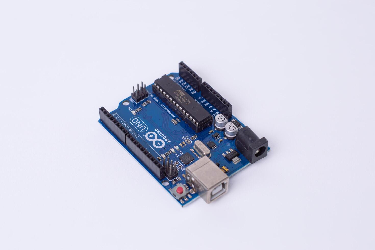 Malang, March 24, 2025. Side view of Arduino Uno microcontroller board on white background. DIY electronics, robotics, embedded system, prototyping hardware photo