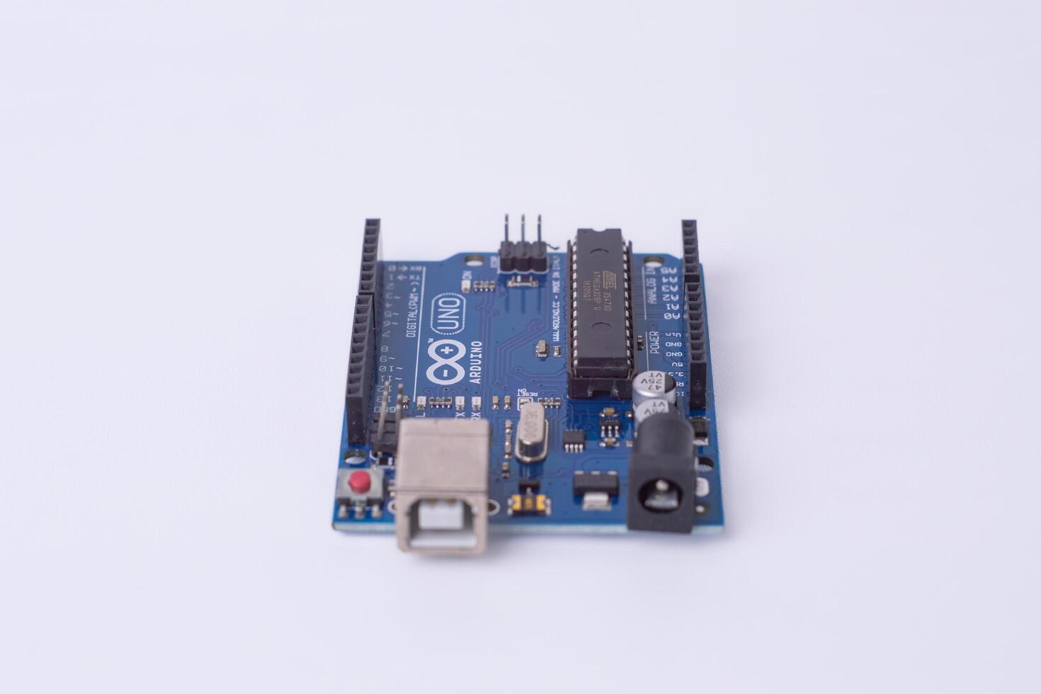 Malang, March 24, 2025. Front view of Arduino Uno microcontroller board on white background. DIY electronics, robotics, embedded system, prototyping hardware, open-source platform for coding. photo