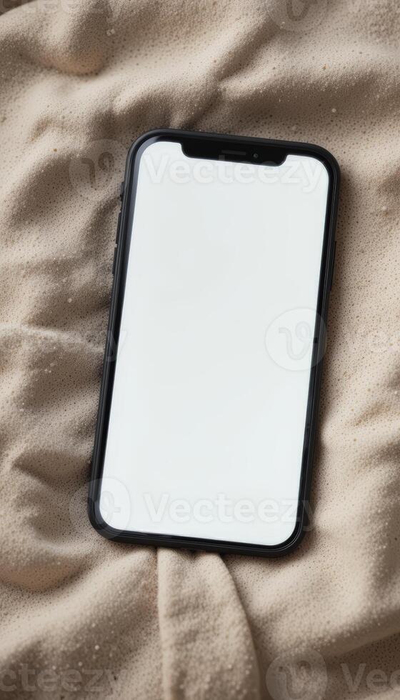 Blank Smartphone Screen . A modern smartphone with a large blank white display lying on a fabric surface, ready for mobile app or UI presentation. photo