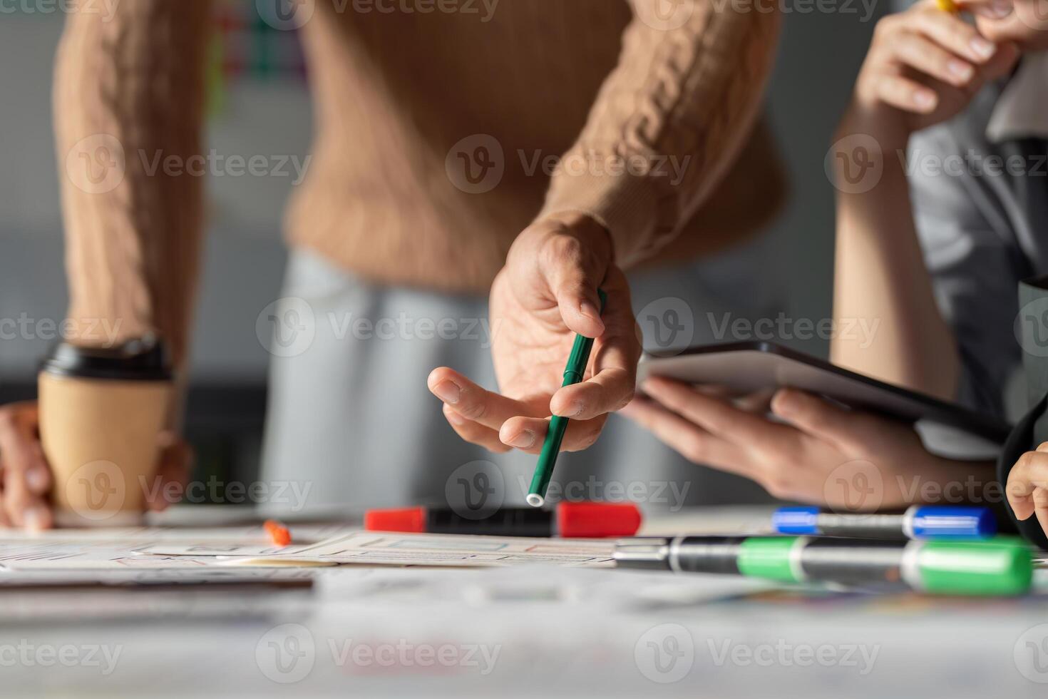 Team discussing UX UI strategies with sketches and digital tools in a workspace. photo