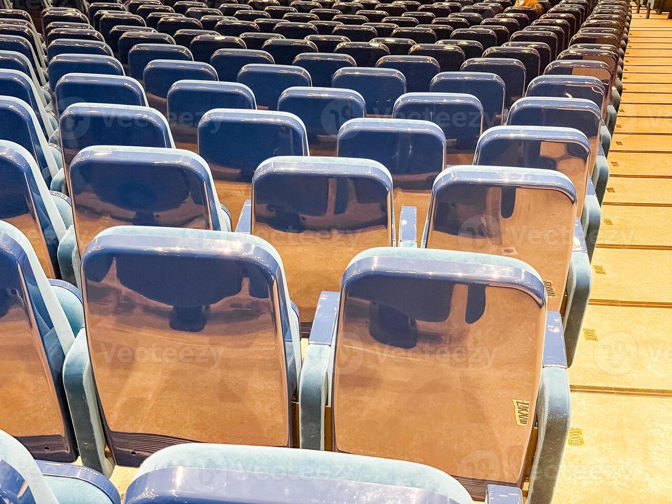 Rows of empty auditorium seats with glossy backs. Event preparation, public gathering, and modern infrastructure in an indoor conference or performance venue. photo