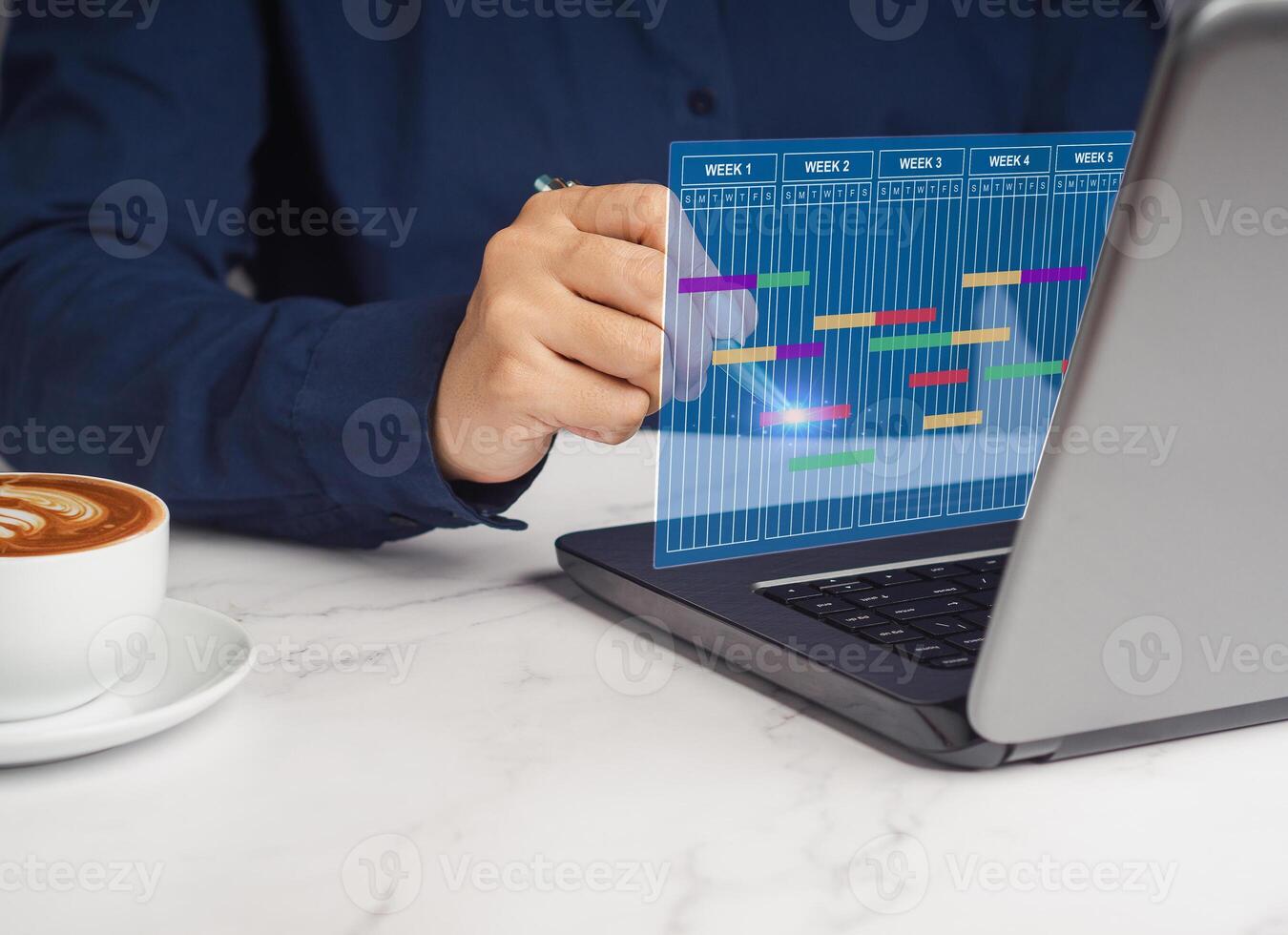 Project manager working on a laptop and updating tasks and milestones progress planning. photo