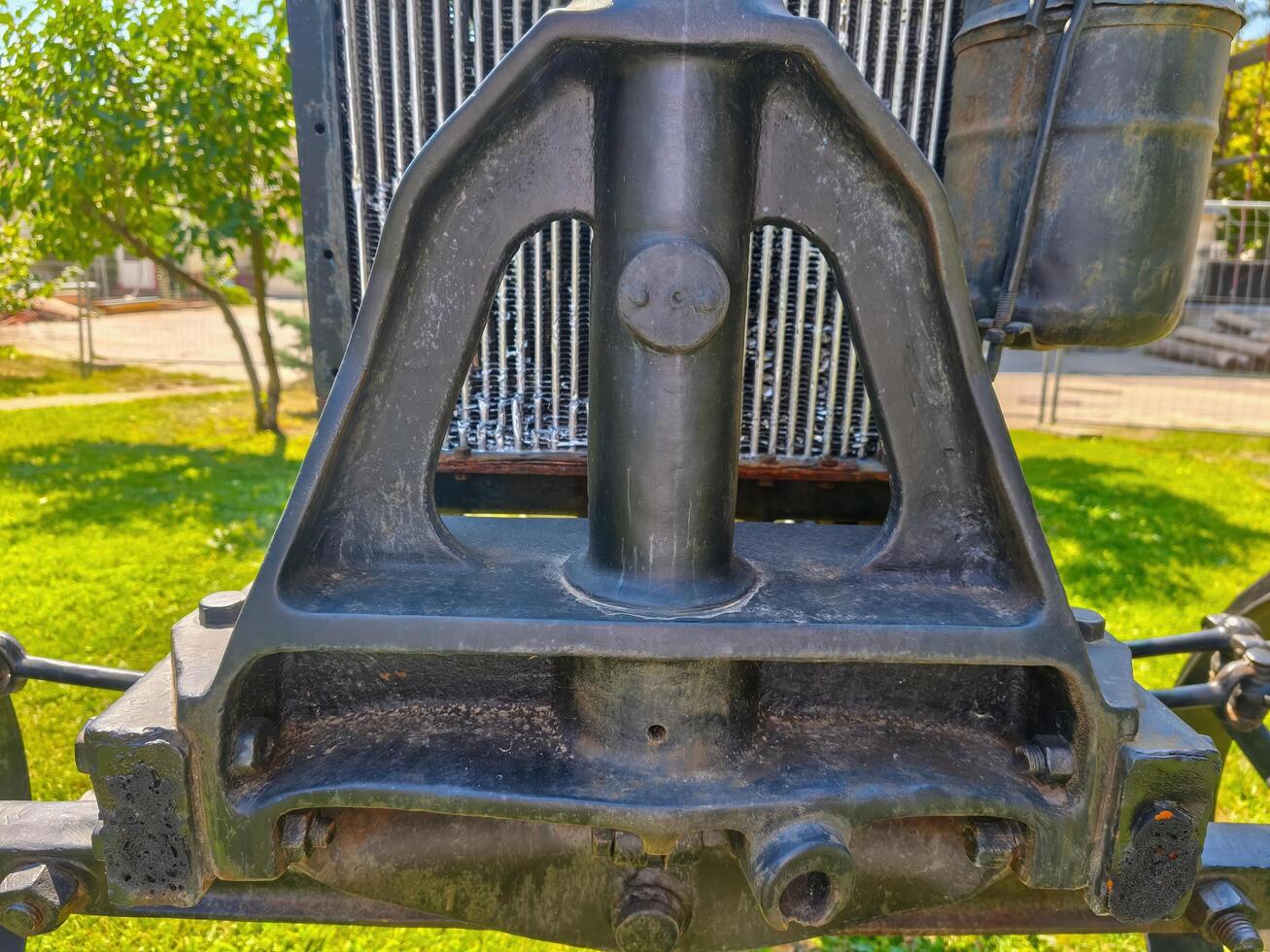 The front of a vehicle has a black frame and a black radiator. The radiator is attached to the frame with bolts photo