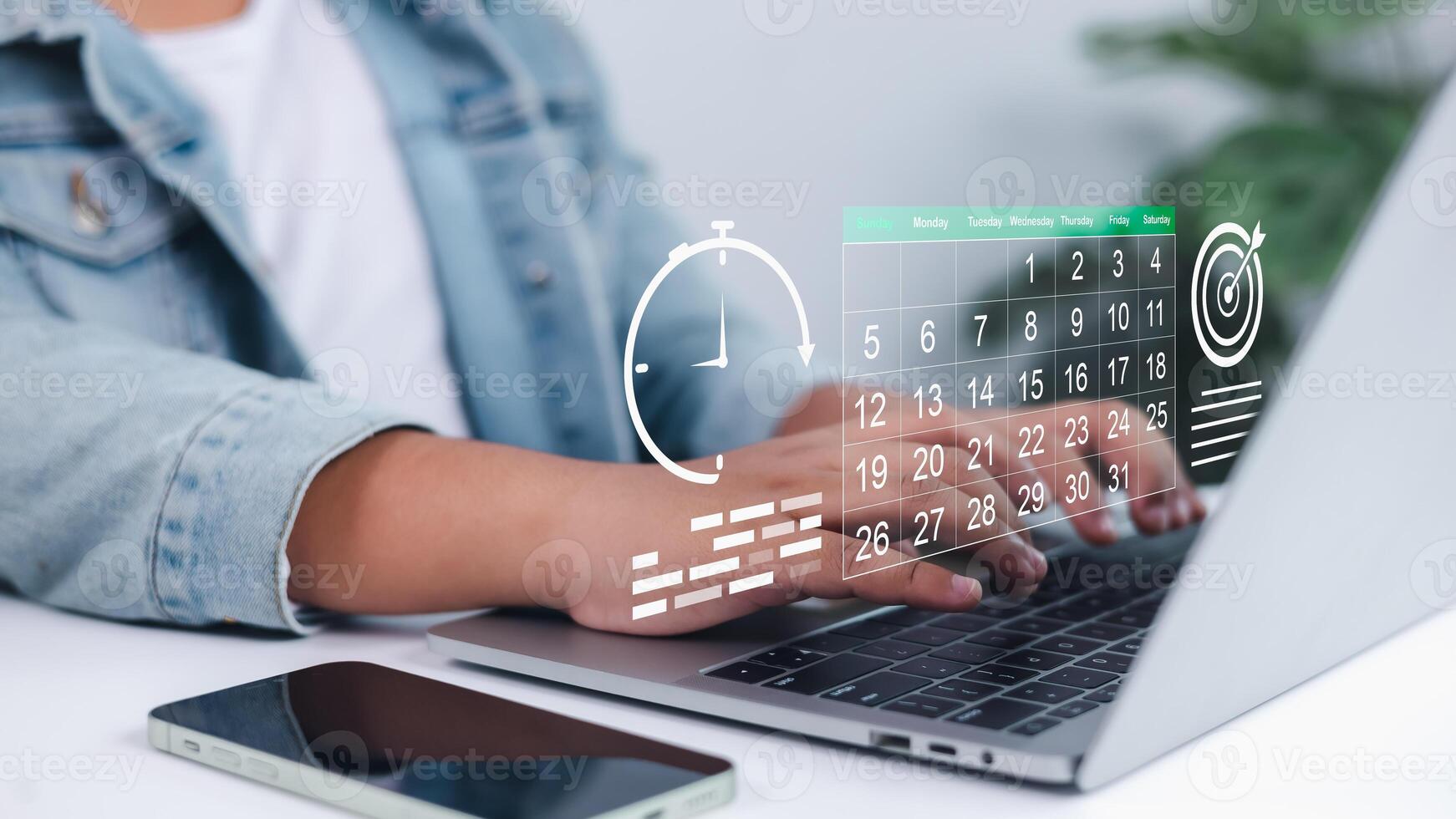Person using laptop with digital calendar, clock, and target icons overlay, symbolizing effective time management, strategic planning, goal setting, and improving work efficiency and productivity photo