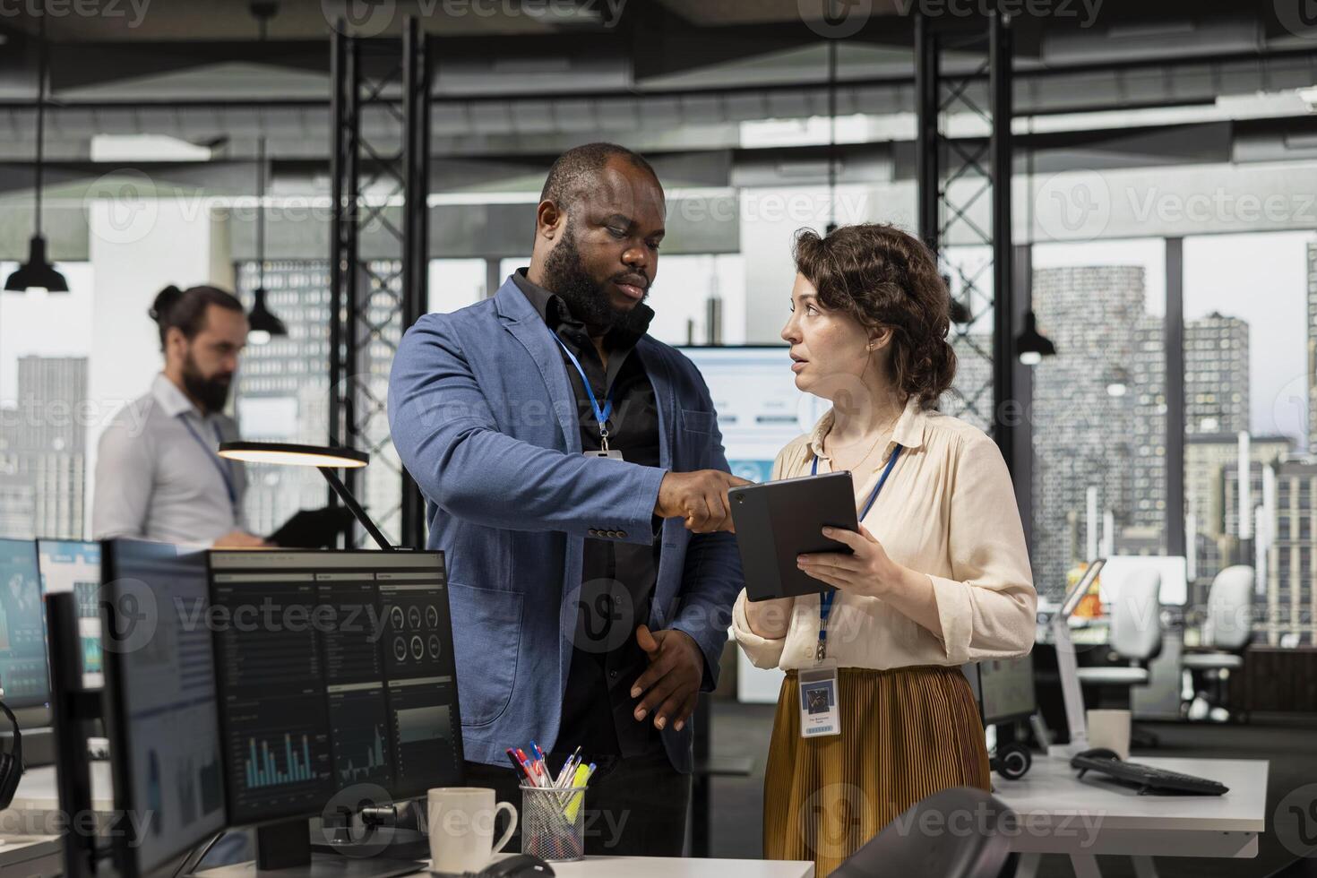 Diverse group of employees collaborate on project planning and analysis, using data from charts on tablet to drive performance metrics. Fostering teamwork and a workplace alliance. photo