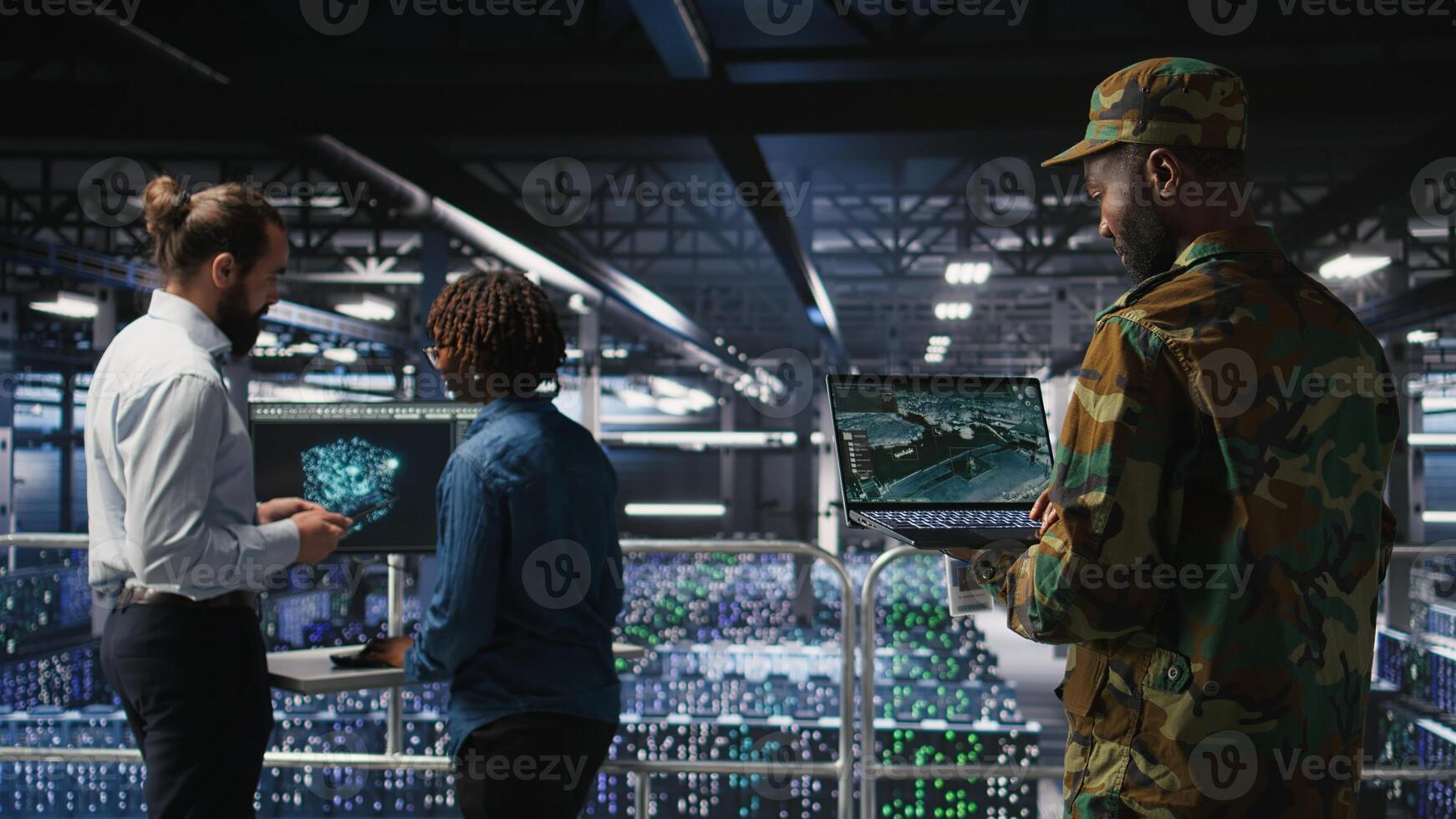 Military technician in data center monitoring warfare drone telemetry on laptop dashboard. IT specialist in army server room using tactical interface on notebook to support aerial operations photo
