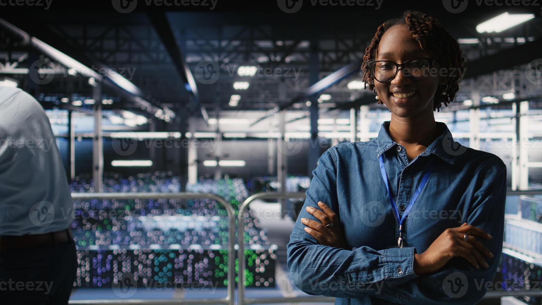 Portrait of smiling data center admin next to coworkers running diagnostics on equipment to identify errors. Happy woman next to IT experts working to prevent failure and minimize downtime, photo