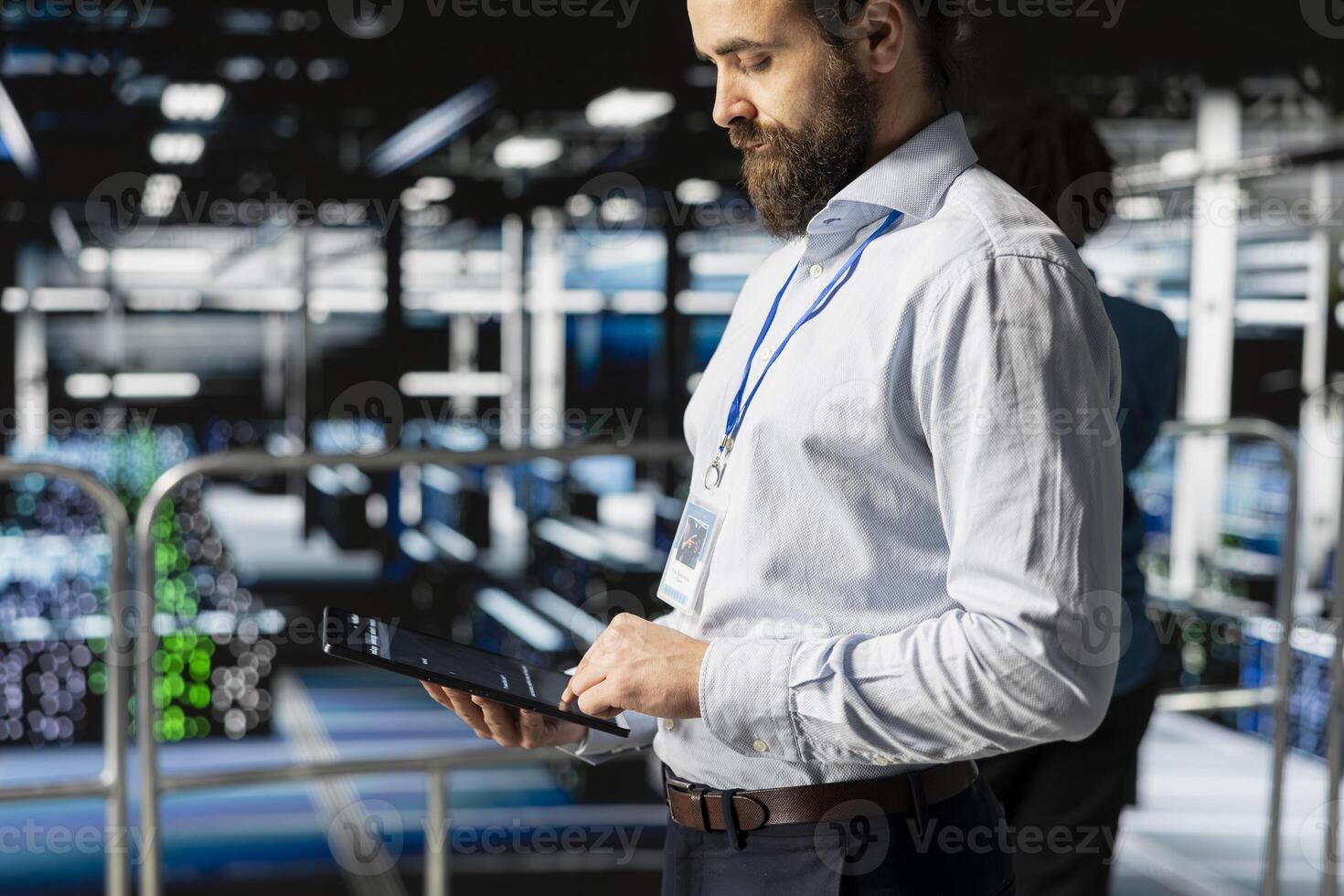 Technician holding tablet to review system diagnostics on server farm platform, doing machine learning automatization. Data center programmer doing maintenance with artificial intelligence. photo