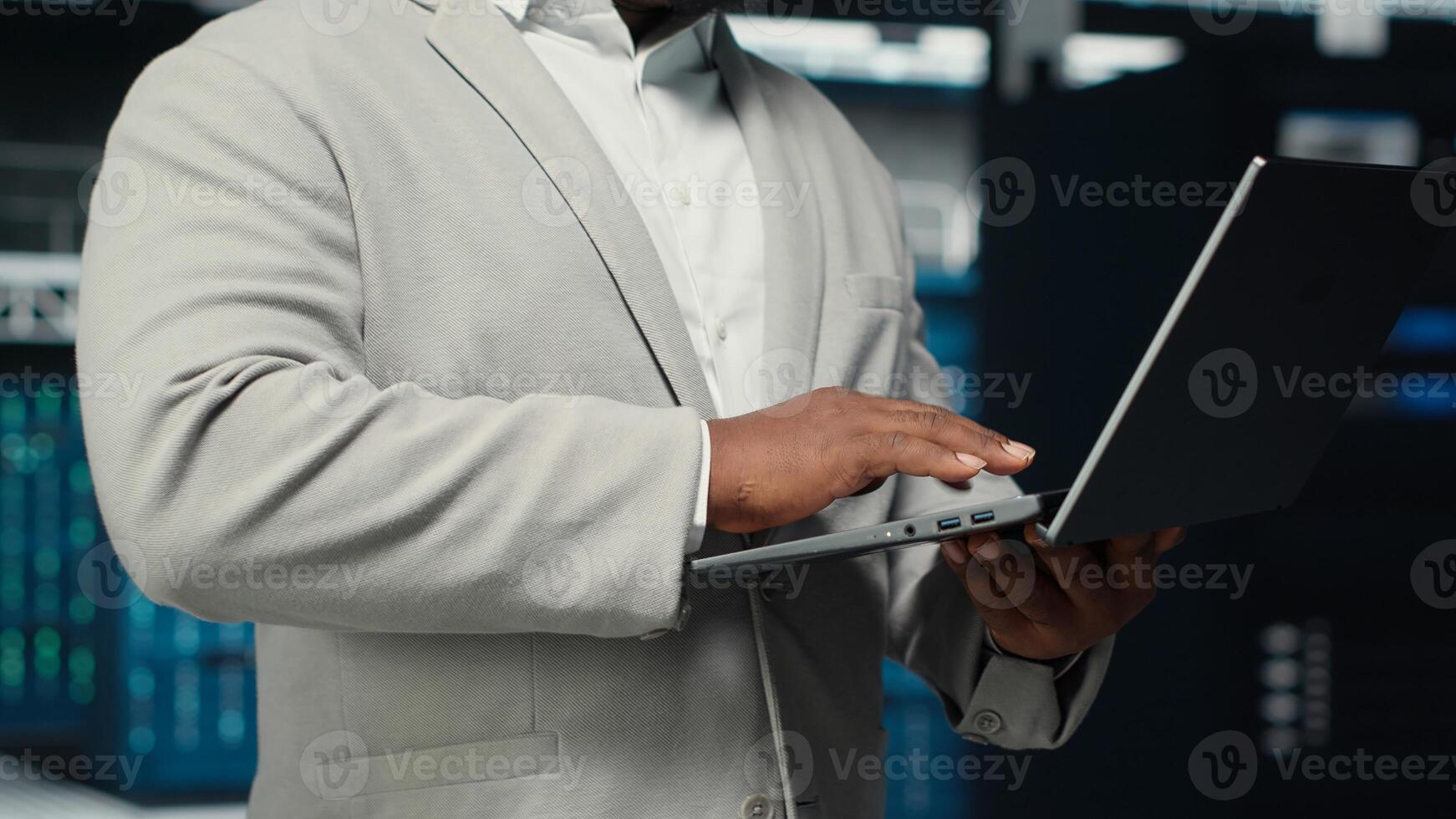 Close up of engineer walking in data center workplace, checking gear for system stability. IT specialist overseeing server farm, configuring mainframes, optimizing performance photo