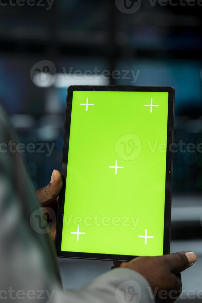 Close up of server farm software developer using mockup tablet to repair equipment storing datasets. Data center worker using green screen device to debug mainframes doing computational operations photo