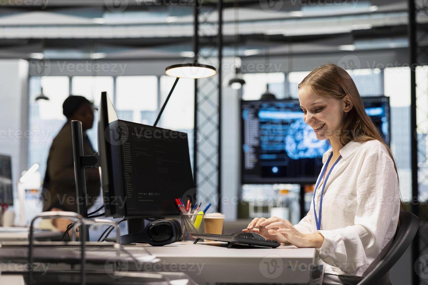 Cheerful junior dev writing code, developing machine learning APIs. Happy young female engineer working in office, troubleshooting software errors using artificial intelligence tech photo