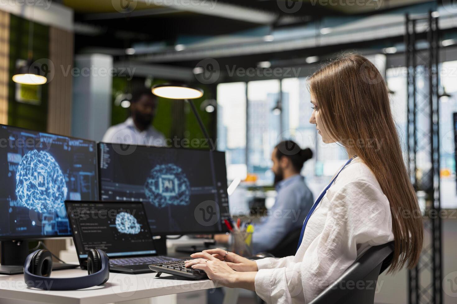 Female admin using multiple devices consulting AI LLM chatbot for tips on how to enhance system performance. Young tech company worker doing internship relying on AI assistant to automate manual tasks photo