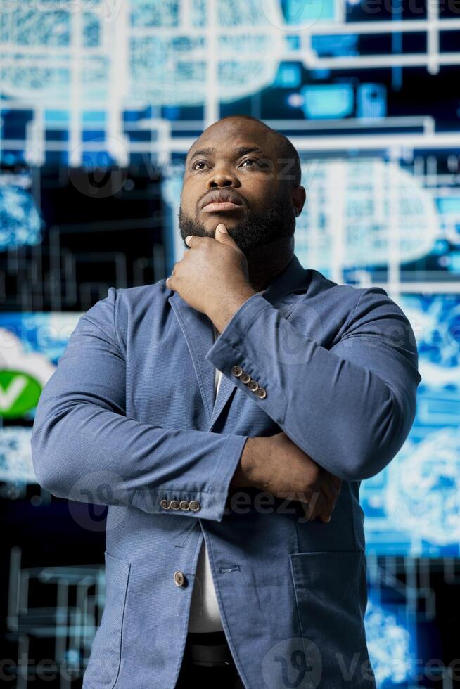 Black IT professional coding for futuristic AI brain blueprints in the background, reflecting AI research through neural networks and deep learning platforms. Intelligent algorithmic thinking. photo