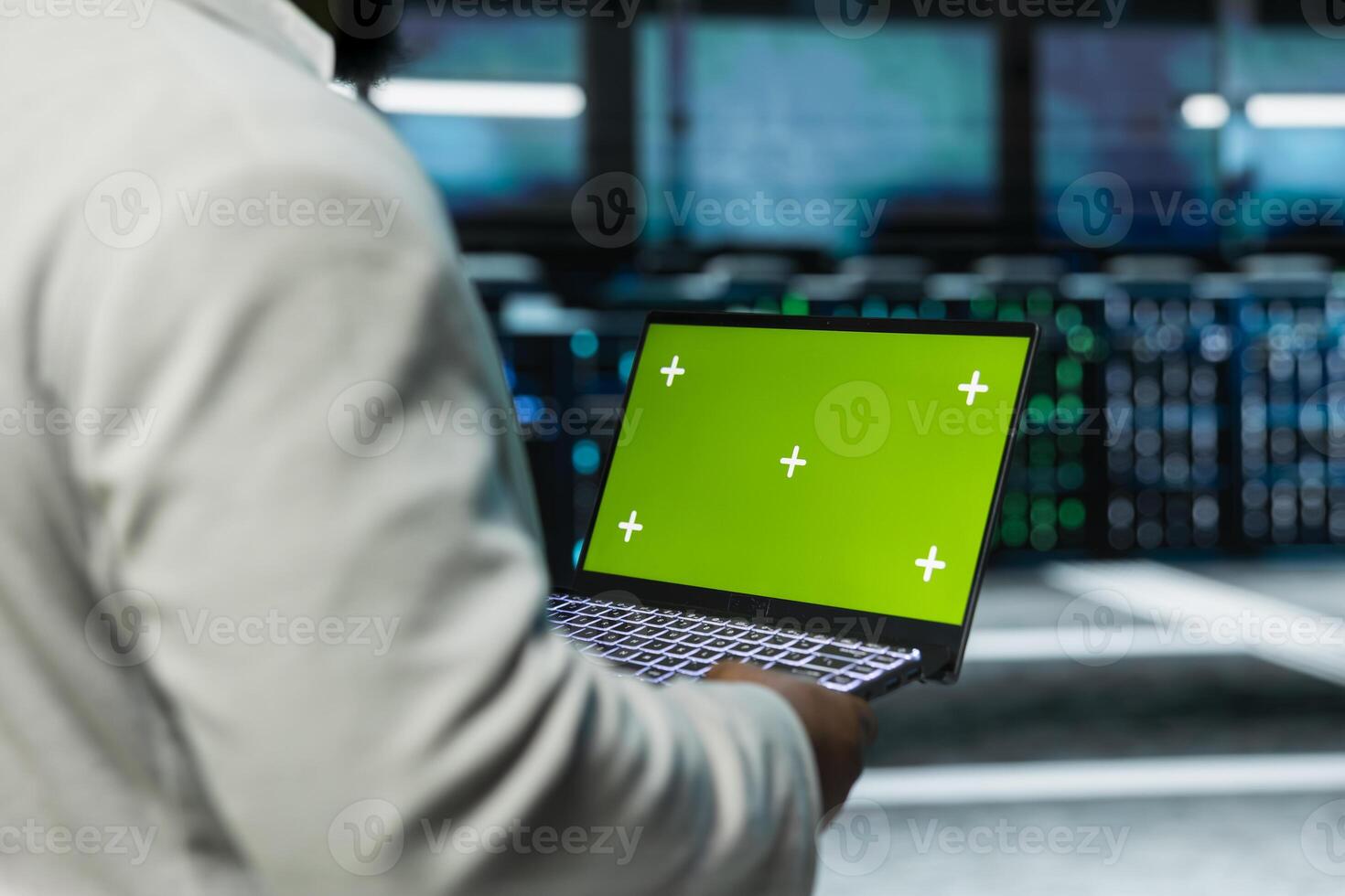 Server hub developer scanning gear using green screen laptop, fixing network issues affecting rigs. Programmer in data center runs system diagnostic tests on chroma key notebook photo