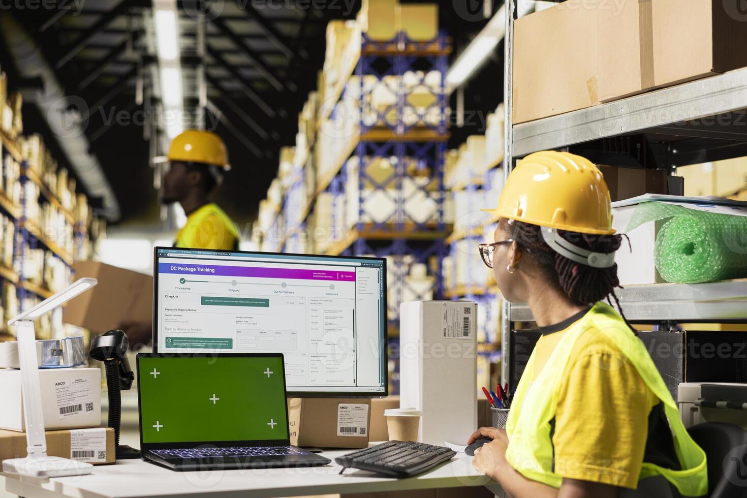 E-commerce worker registering airway bill numbers in the system with mockup, using shipping labels data for package tracking service. Using green screen in warehouse with storage racks. photo