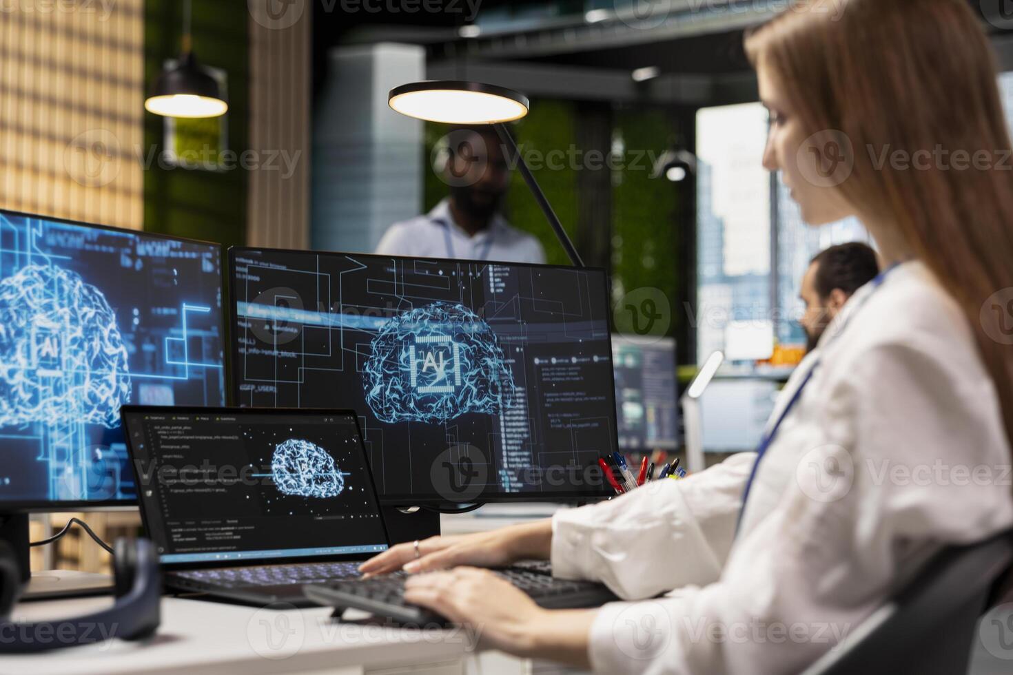 Female engineer developing applications using AI LLM chatbot on multiple devices. Worker doing internship in tech startup relying on artificial intelligence assistant to debug applications photo