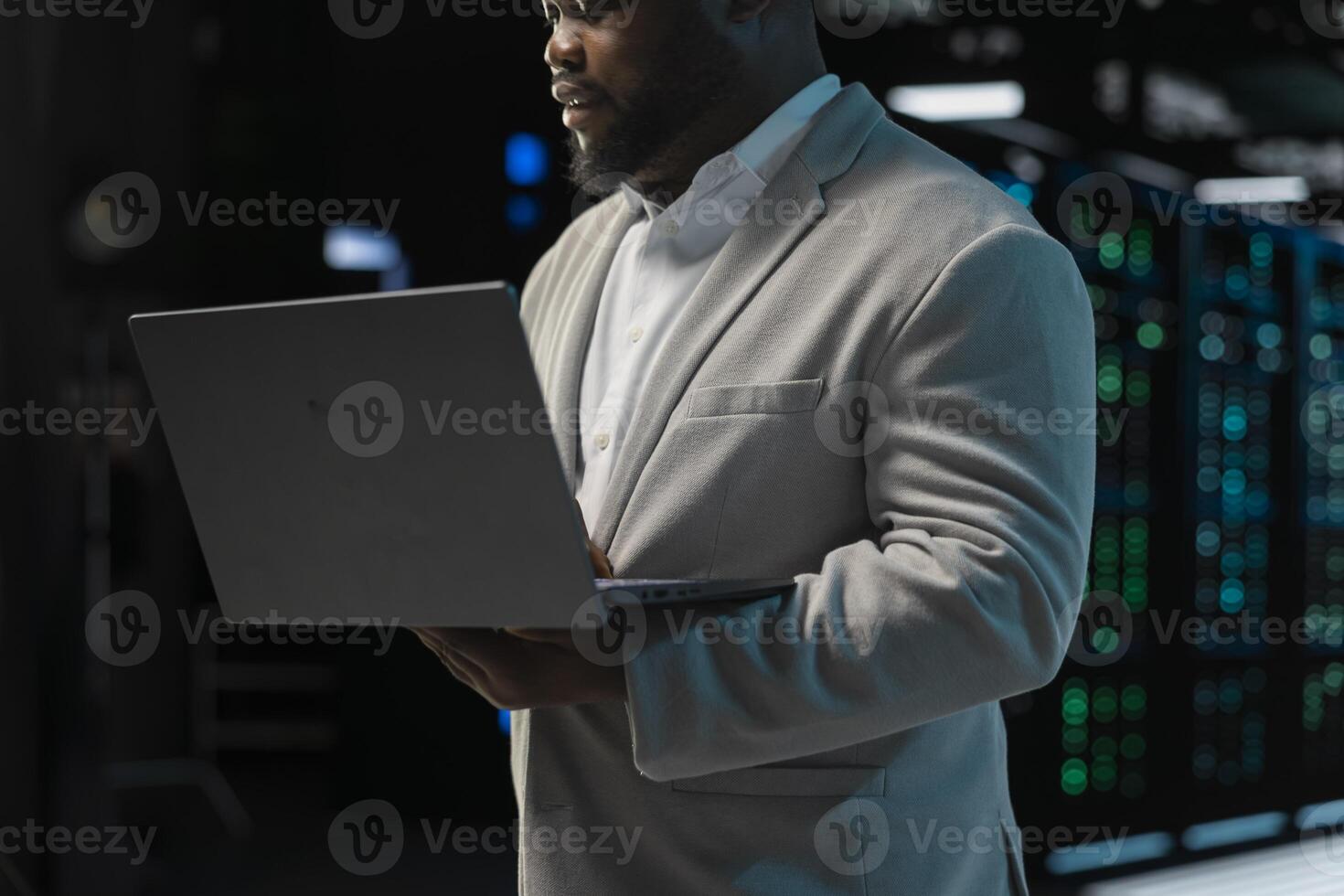 Close up of admin in server farm managing infrastructure systems, checking recovery plan on laptop. Data center IT expert monitoring performance, making sure mainframes are functioning optimally photo