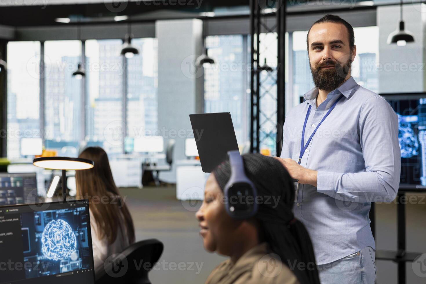 Portrait of team leader supervising programmers at work training deep learning models for anomaly detection. Supervisor overseeing IT workers using artificial intelligence in office to do tasks photo