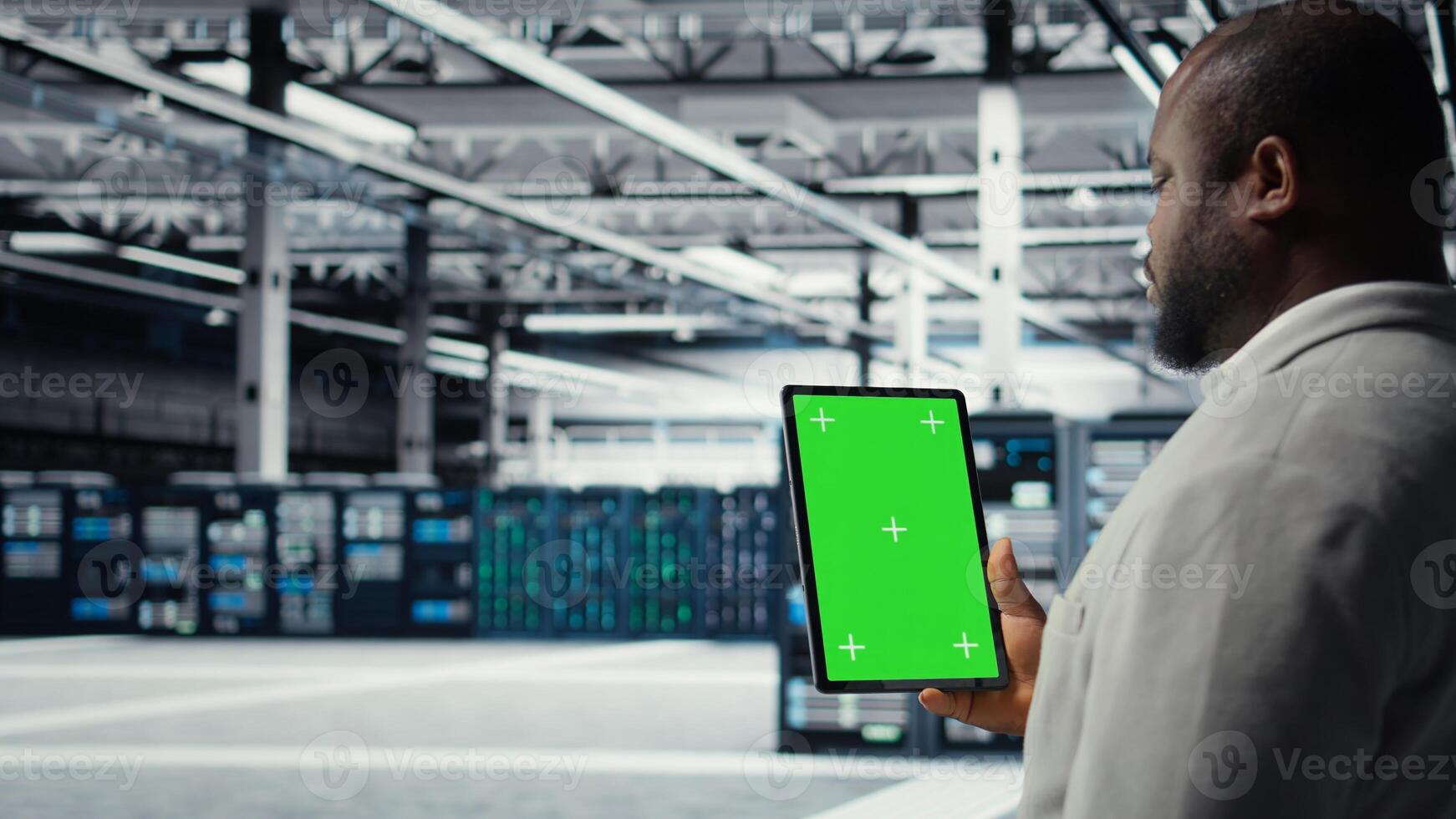 Admin working in server farm using isolated screen tablet to analyze data. IT expert examining infrastructure in data center using chroma key device, ensuring system integrity and security, camera A photo
