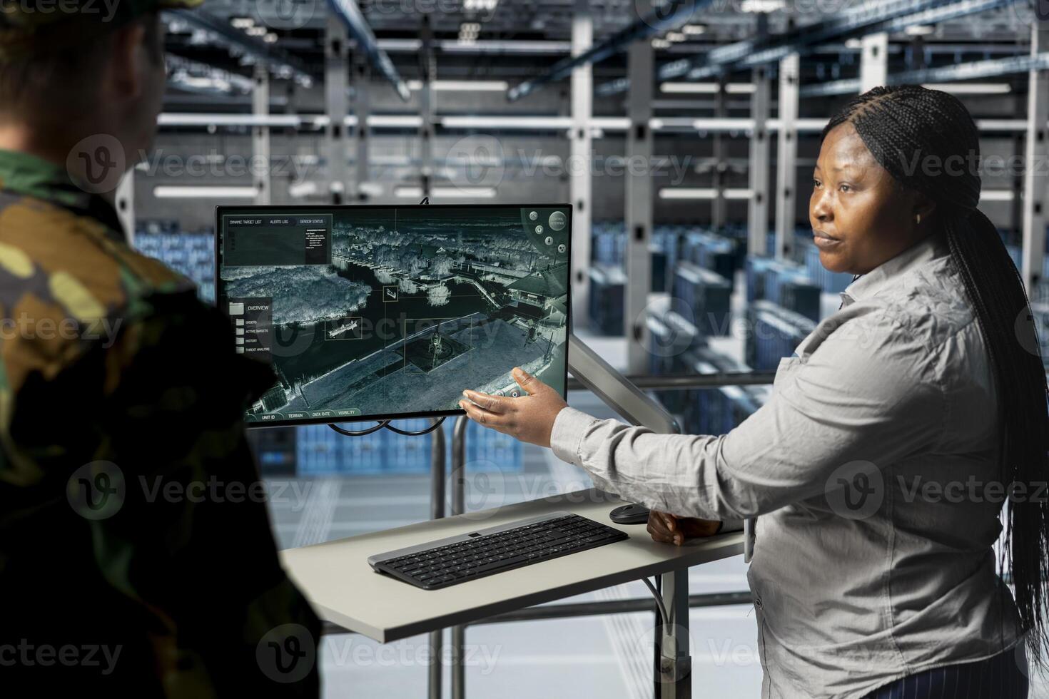 Teamworking army experts in data center confirming target locations using aerial image overlay on monitor. Military units in server room gathering strategic terrain data via satellite systems photo