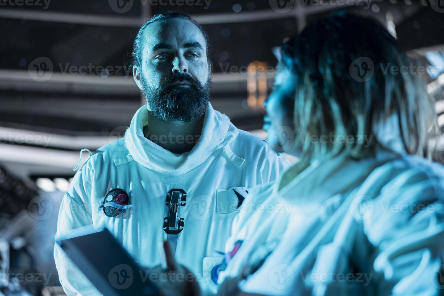Team of astronauts verifying mission parameters on tablet to ensure safe operation during long distance space travel. Teamworking cosmonauts updating flight log during cosmic journey photo