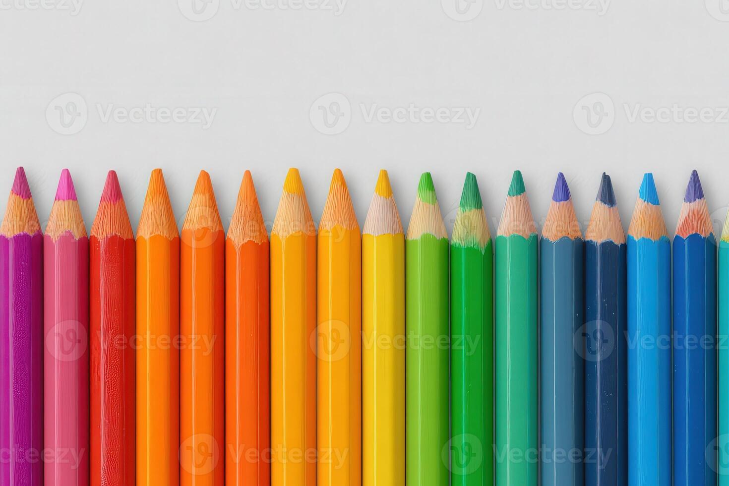 A vibrant array of sharpened colored pencils is neatly arranged in a gradient, showcasing shades from pink to purple. The pencils are placed on a clean white surface, emphasizing their bright colors. photo