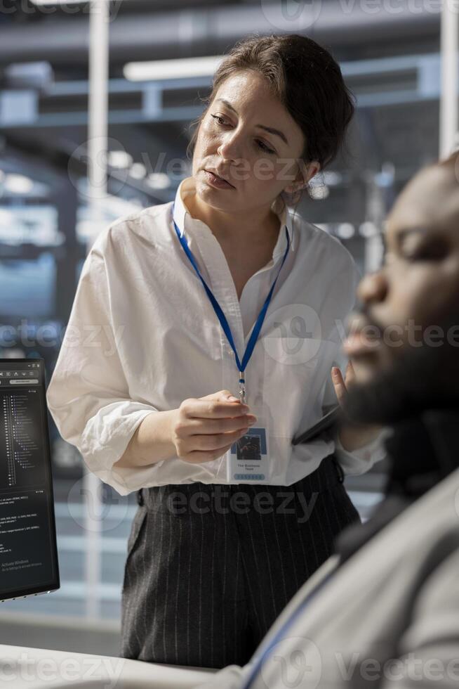 Data center engineering team using PC to update servers tech, configuring infrastructure. Server hub teamworking colleagues reviewing hardware analytics, ensuring reliable network operations photo