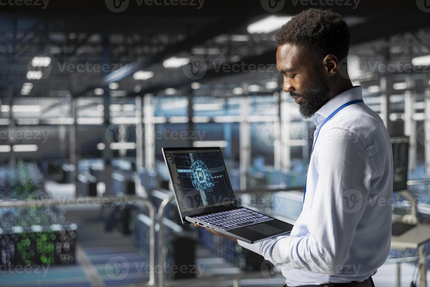 Black male technician in data center using laptop for neural network LLM visualization monitoring. Data scientist on industrial platform overseeing server clusters machine learning processes. photo