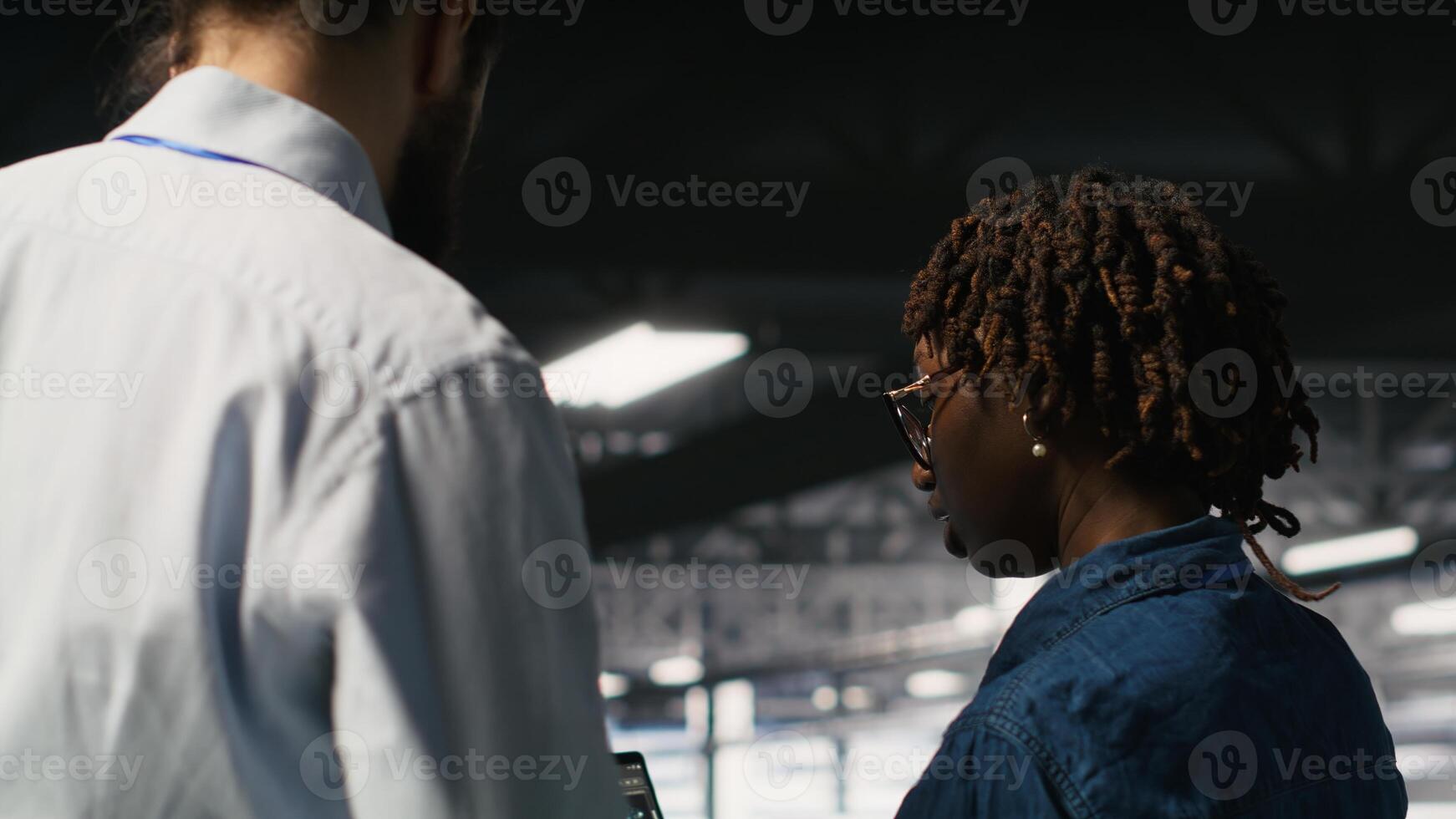 Server farm manager overseeing work done by engineer reviewing neural network code and LLM visualization dashboards. Team leader supervising worker monitoring AI system performance photo