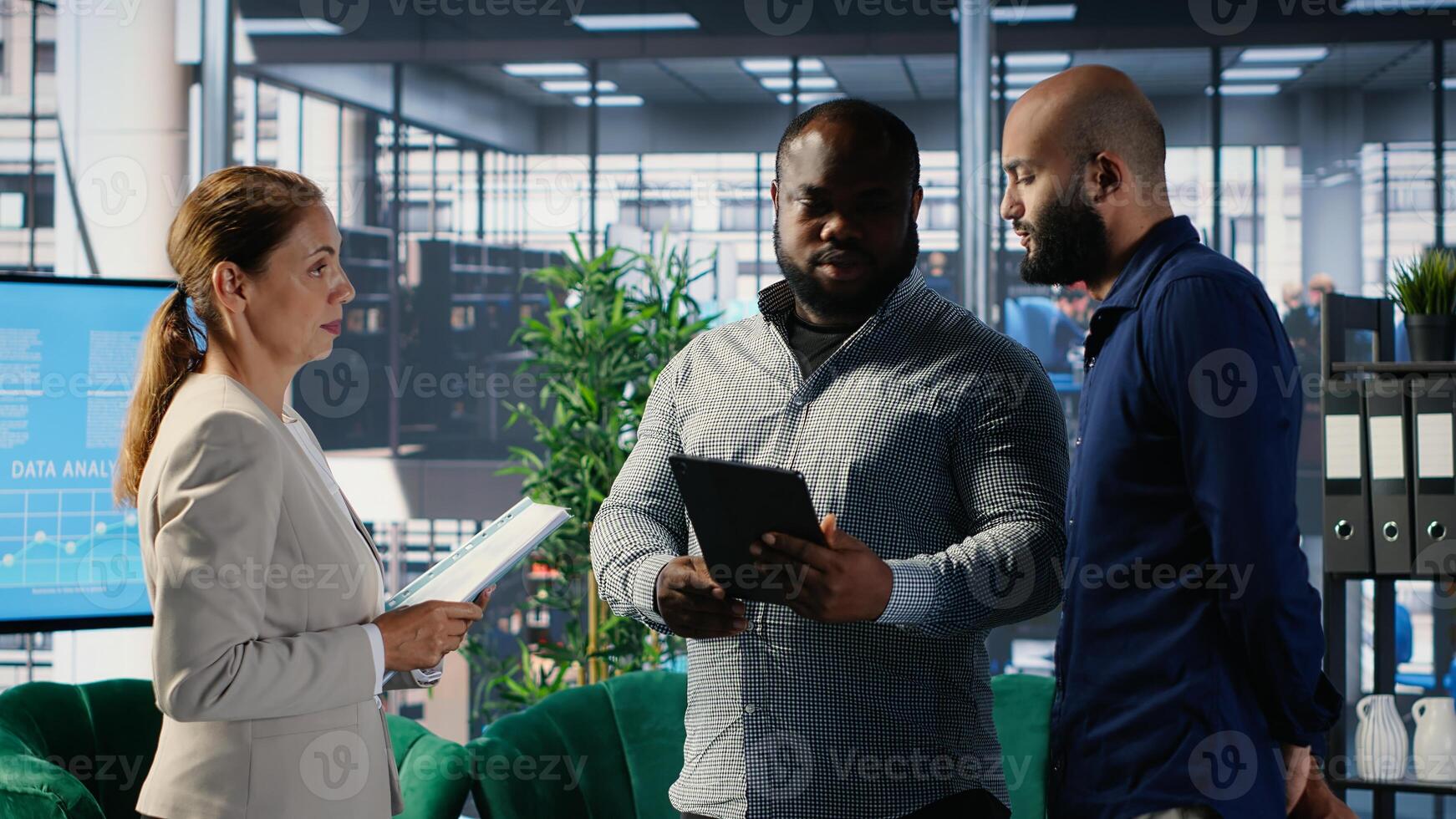 Diverse group of CEOs applying data analysis and strategic thinking to guide partnership decisions, using research and performance metrics. Multicultural perspectives in office lobby. Camera B. photo