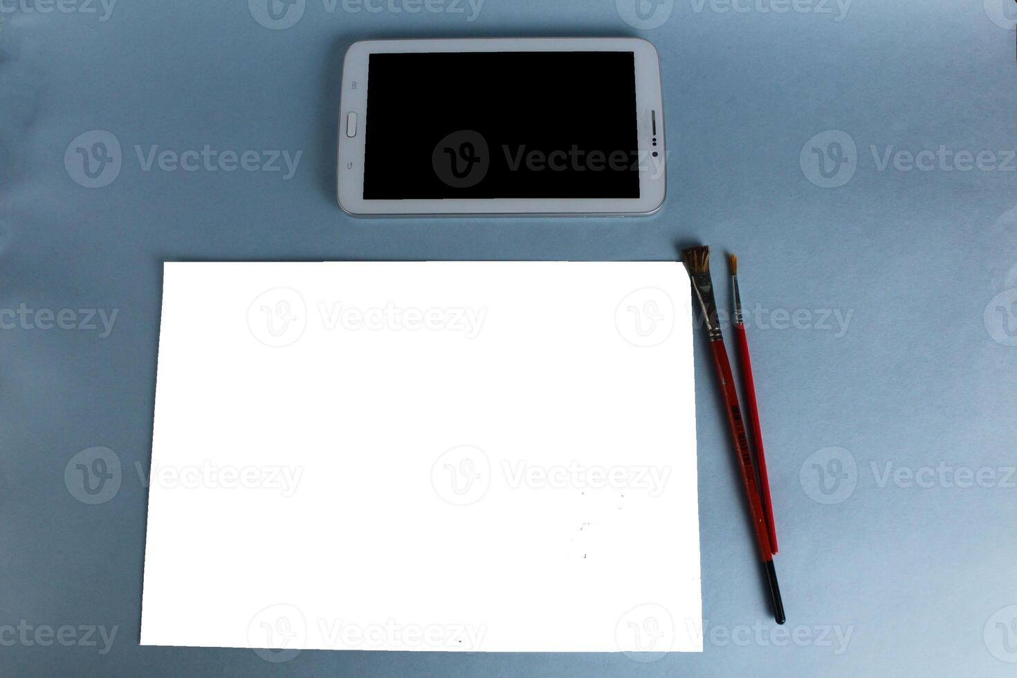 online training. drawing tablet and sheet of white paper with a pattern on a light blue background with a mock up and a place for text photo