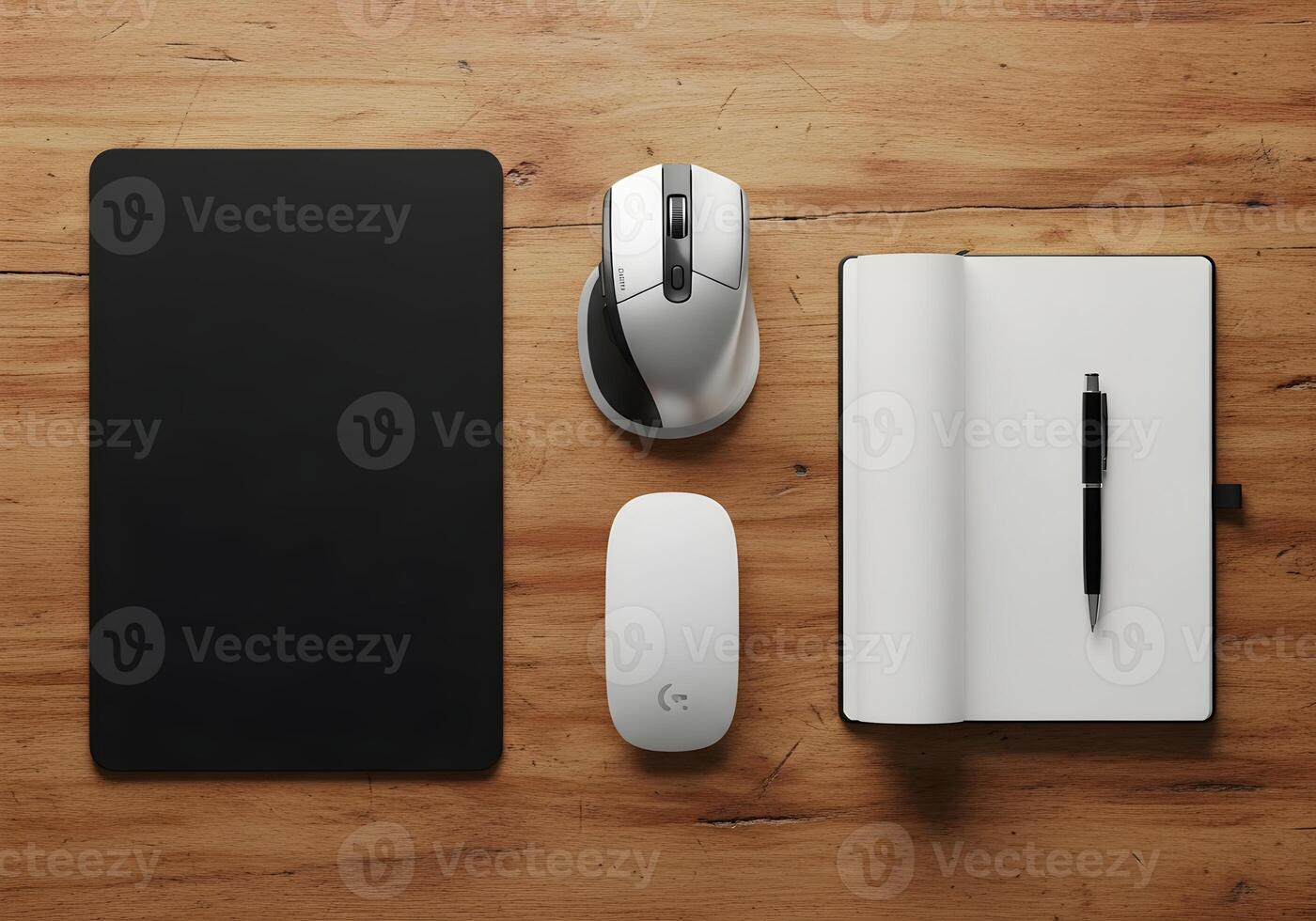 Flat lay composition of simple workstation including mouse, mousepad, notebook, and pen on wood texture desk with clean light photo